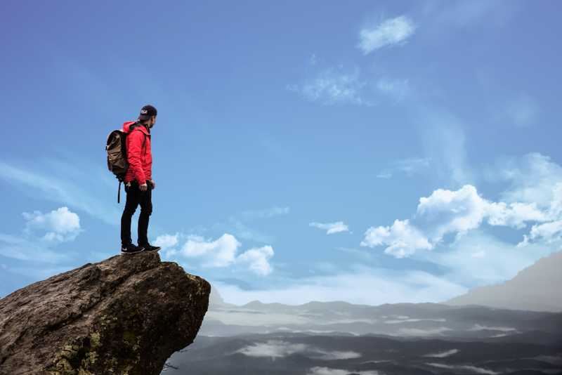 Photo of a man standing on a cliff.